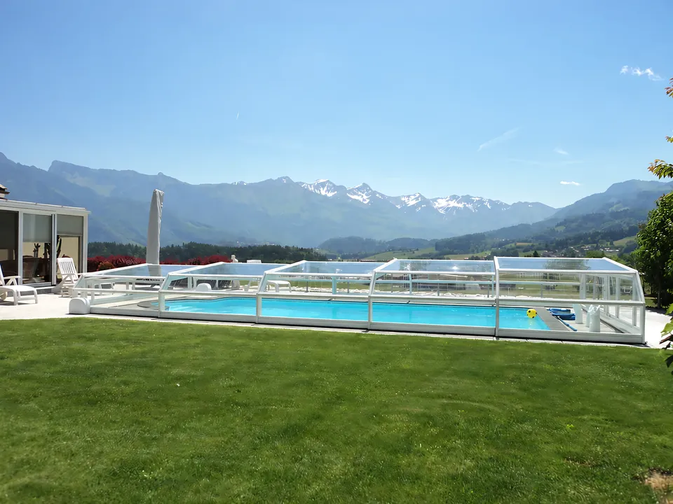 Abri de piscine bas blanc, face aux Alpes