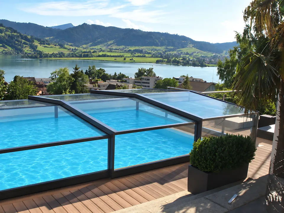 Abri de piscine bas sur terrasse en bois, face au lac