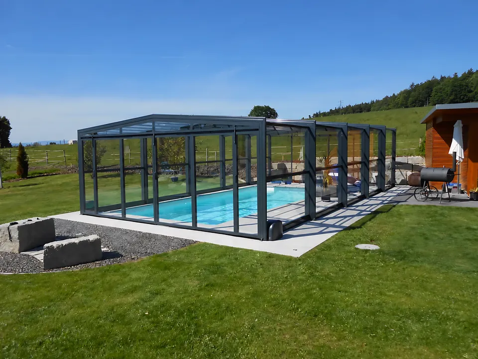 Abri de piscine haut blanc, au pied de la montagne