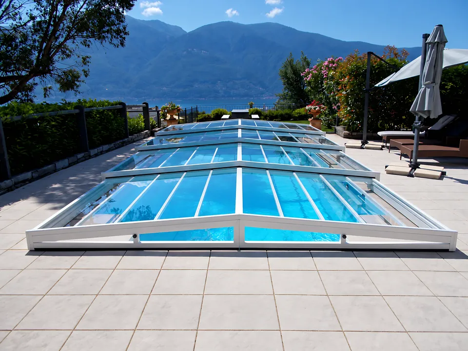 Abri de piscine bas blanc, face au lac et aux montagnes